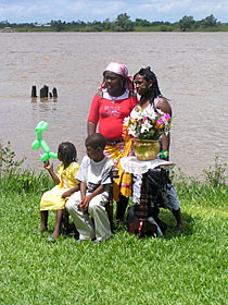 Een Surinaamse familie poseert aan de oever van de Suriname-rivier tijdens Keti Koti